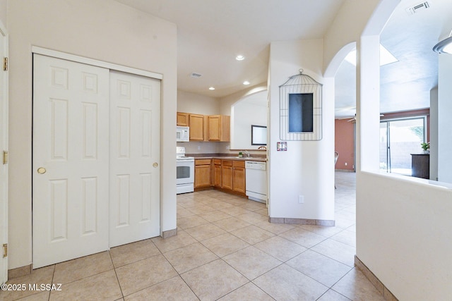 kitchen featuring light tile patterned floors, white appliances, visible vents, and baseboards