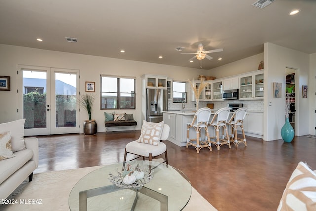 living room featuring french doors and ceiling fan