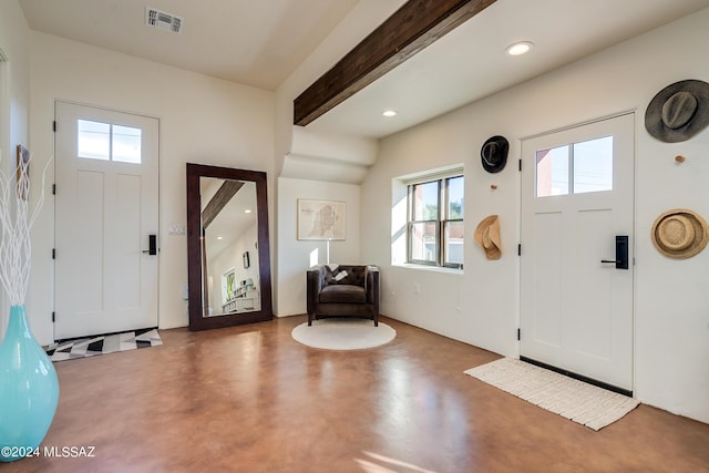 foyer with beamed ceiling and concrete floors