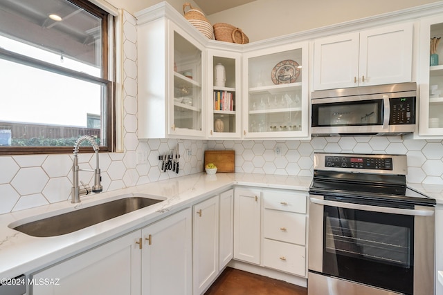 kitchen with white cabinetry, sink, backsplash, and appliances with stainless steel finishes