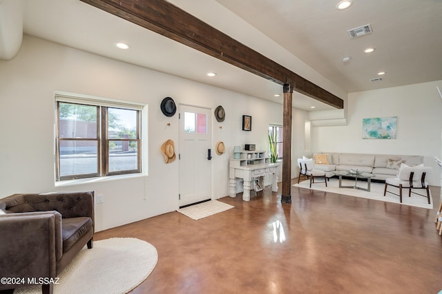 entrance foyer with plenty of natural light, concrete floors, and beam ceiling