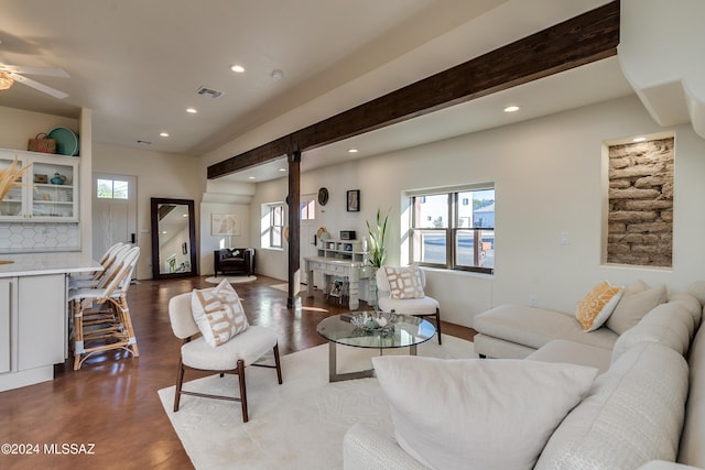 living room with ceiling fan, beam ceiling, and concrete floors