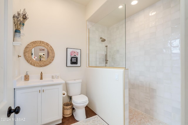 bathroom featuring vanity, toilet, and tiled shower