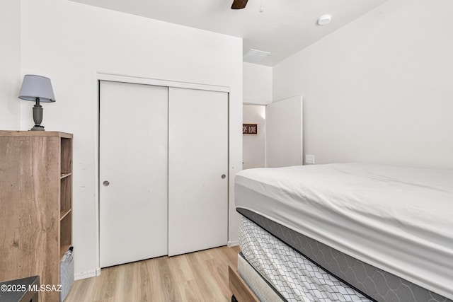 bedroom featuring light hardwood / wood-style floors, a closet, and ceiling fan