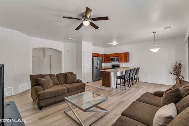 living room with ceiling fan and light hardwood / wood-style floors