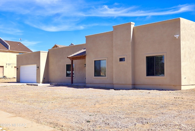 view of front of house featuring an attached garage and stucco siding