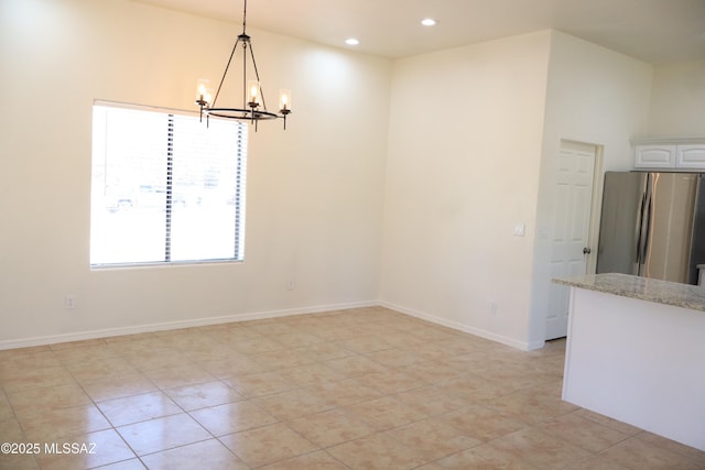 unfurnished dining area featuring light tile patterned floors, recessed lighting, an inviting chandelier, and baseboards