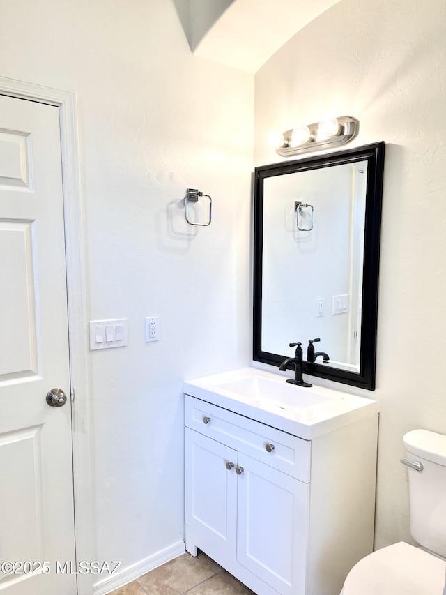 bathroom with toilet, tile patterned floors, and vanity