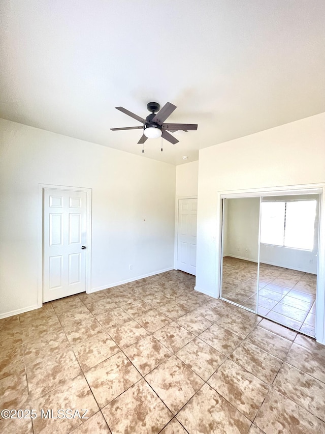 unfurnished bedroom with light tile patterned floors, a ceiling fan, baseboards, and a closet