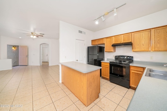 kitchen with sink, light tile patterned flooring, black appliances, and a kitchen island