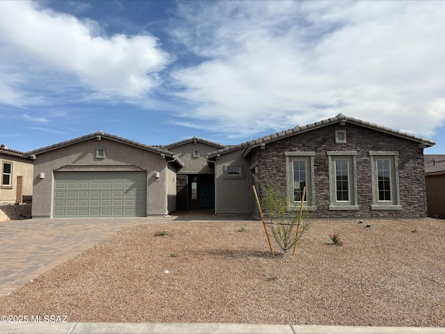 single story home with stucco siding, decorative driveway, a tiled roof, and an attached garage