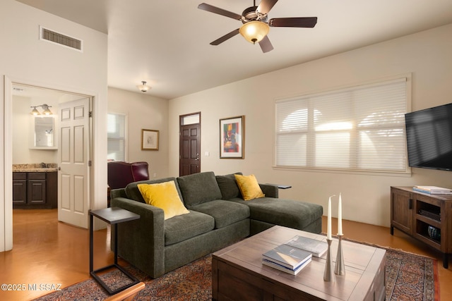 living room with wood-type flooring and ceiling fan