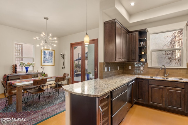 kitchen with sink, decorative backsplash, dark brown cabinetry, and decorative light fixtures