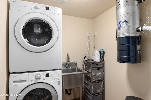 washroom featuring stacked washer and clothes dryer and sink