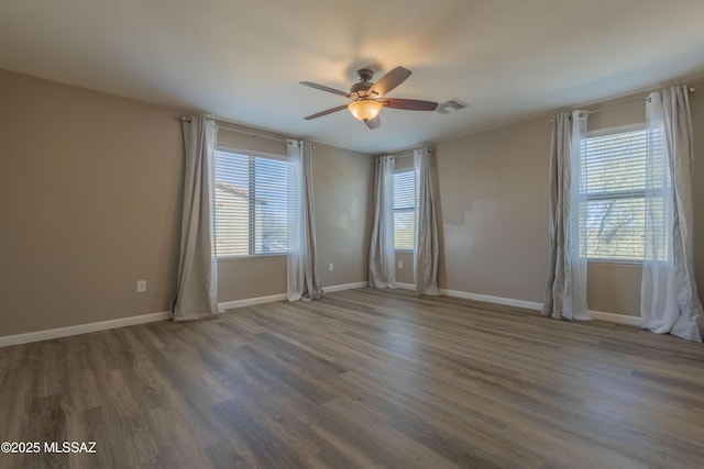 spare room featuring dark wood-type flooring and ceiling fan