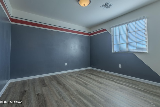 unfurnished room with wood-type flooring