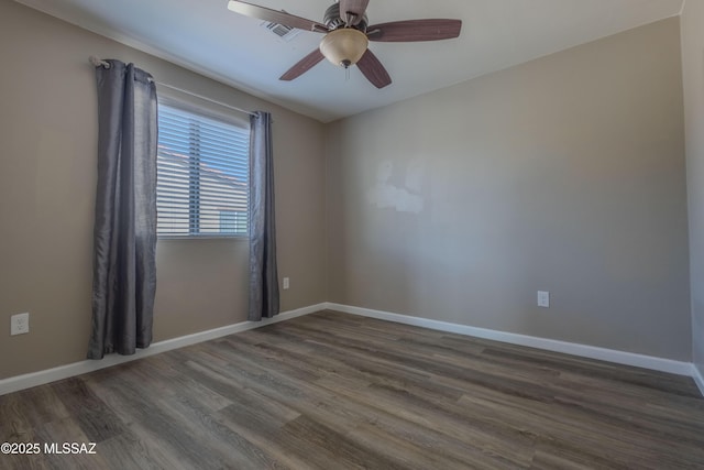 empty room with dark hardwood / wood-style floors and ceiling fan