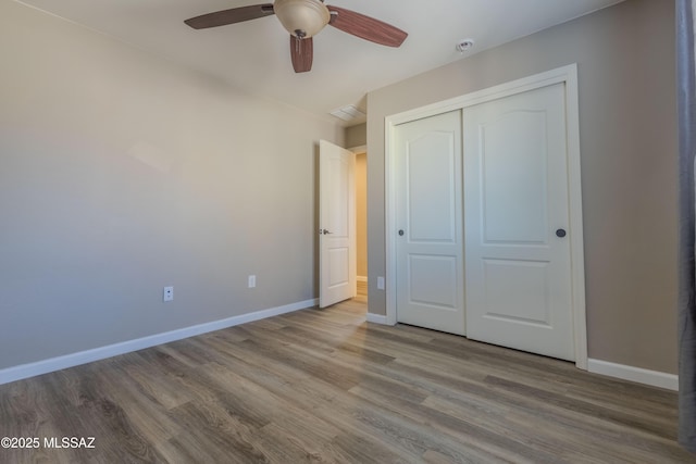 unfurnished bedroom featuring wood-type flooring, a closet, and ceiling fan