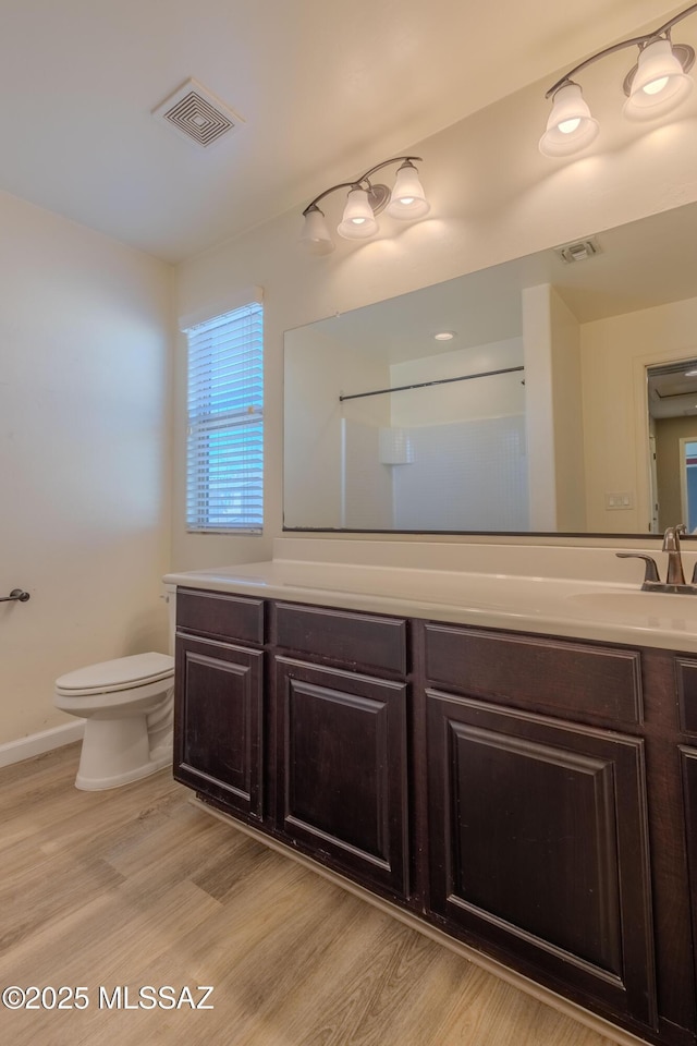 bathroom featuring vanity, toilet, and hardwood / wood-style floors