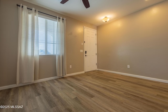 unfurnished room with hardwood / wood-style floors and ceiling fan