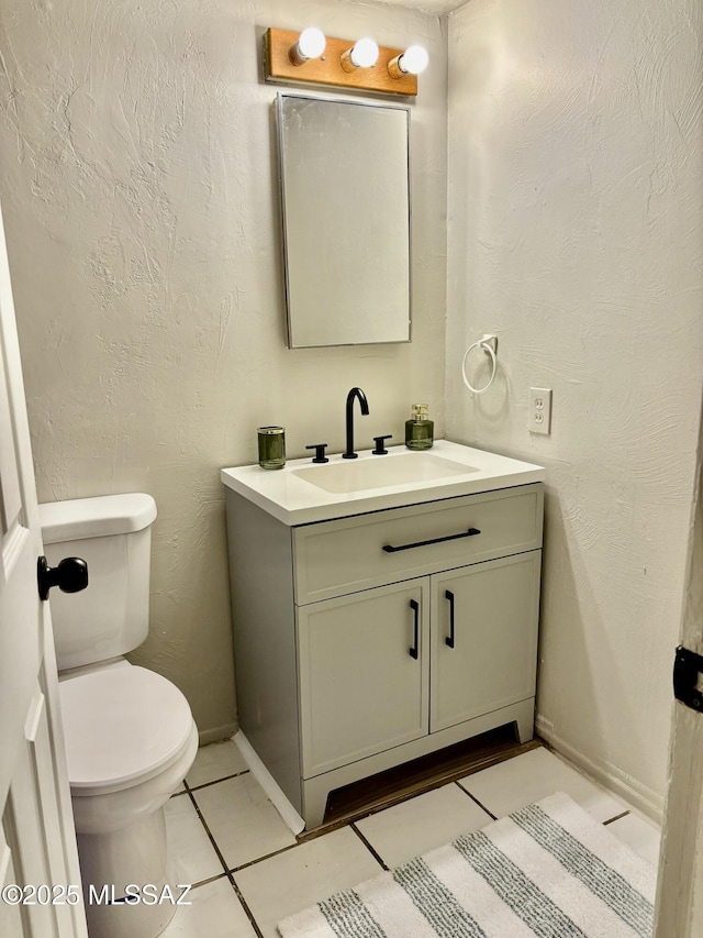 bathroom with vanity, tile patterned floors, and toilet