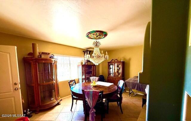 tiled dining room with a chandelier