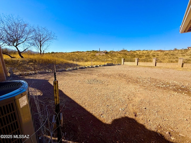 view of yard with a rural view and central AC unit