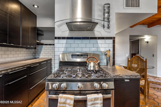 kitchen with visible vents, stainless steel range with gas cooktop, wood counters, wall chimney exhaust hood, and tasteful backsplash