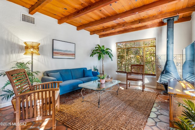 living room featuring visible vents, beamed ceiling, wooden ceiling, and a wood stove