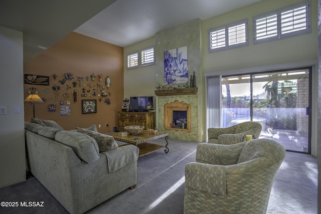 carpeted living room with a towering ceiling and a fireplace