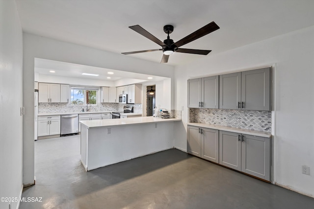 kitchen featuring appliances with stainless steel finishes, sink, gray cabinetry, and kitchen peninsula