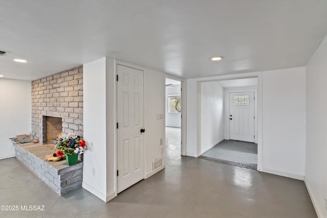 foyer with a fireplace and concrete floors