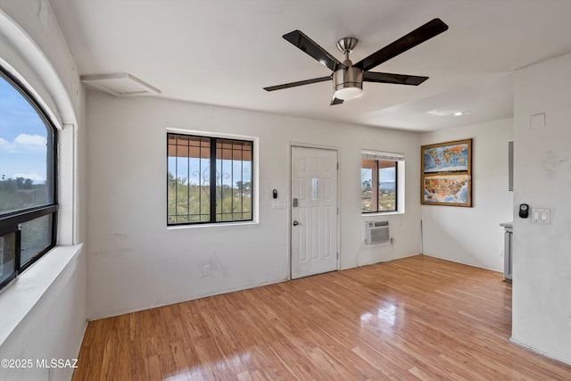 entrance foyer with a wall mounted AC, a wealth of natural light, ceiling fan, and light hardwood / wood-style flooring