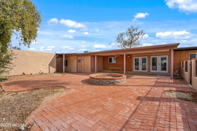 back of property with a hot tub, a patio area, ceiling fan, and french doors