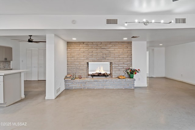 unfurnished living room featuring ceiling fan and a fireplace