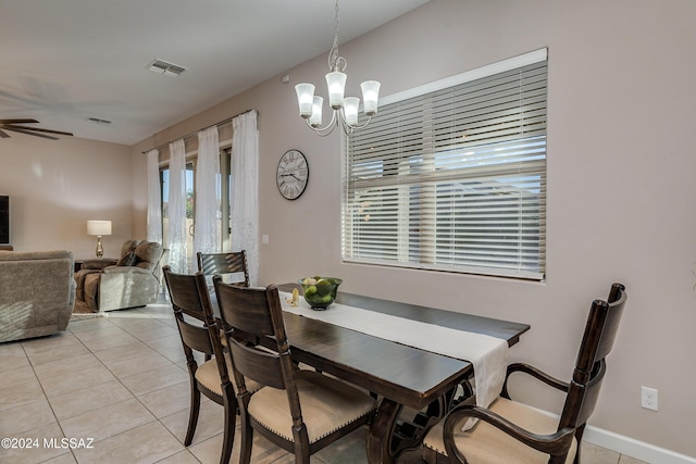 tiled dining area featuring ceiling fan with notable chandelier