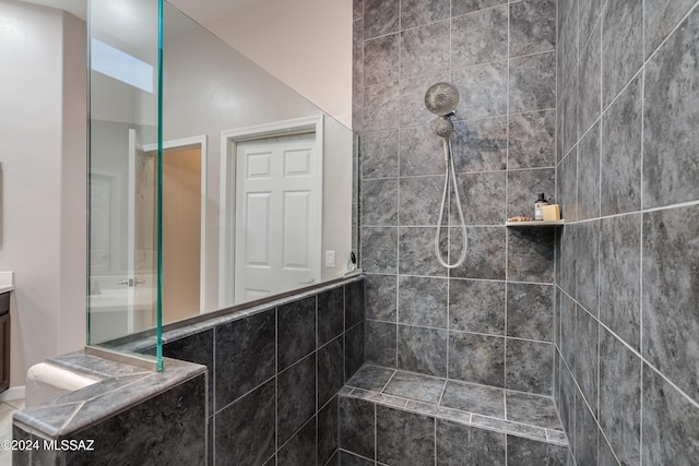 bathroom with vanity and a tile shower