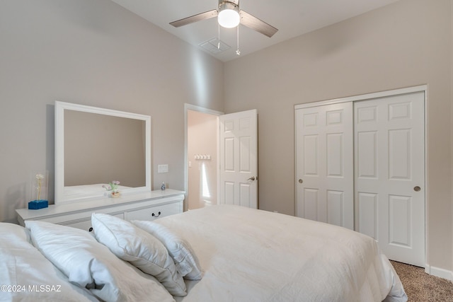 carpeted bedroom with a towering ceiling, a closet, and ceiling fan