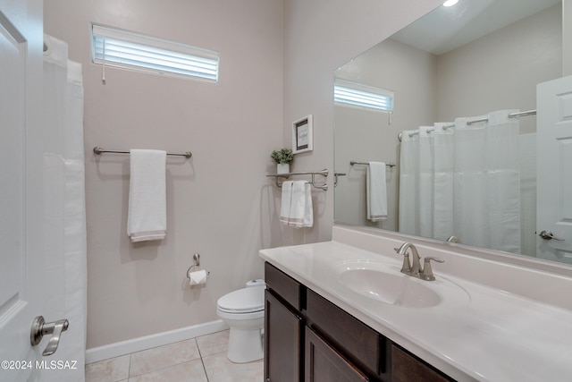 bathroom featuring plenty of natural light, toilet, tile patterned flooring, and vanity