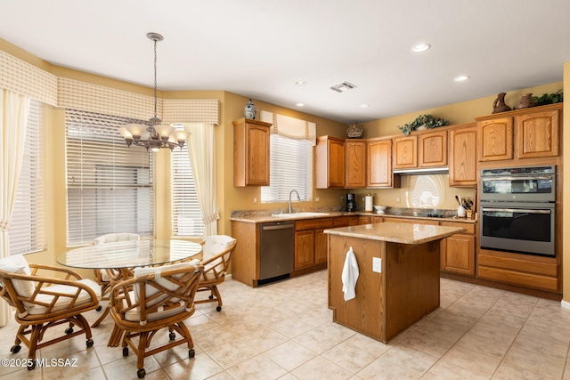 kitchen featuring pendant lighting, sink, stainless steel appliances, a center island, and a chandelier