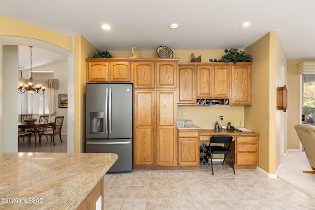 kitchen featuring light tile patterned flooring, built in desk, an inviting chandelier, and stainless steel fridge with ice dispenser