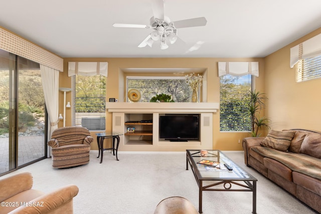 carpeted living room with a ceiling fan and baseboards