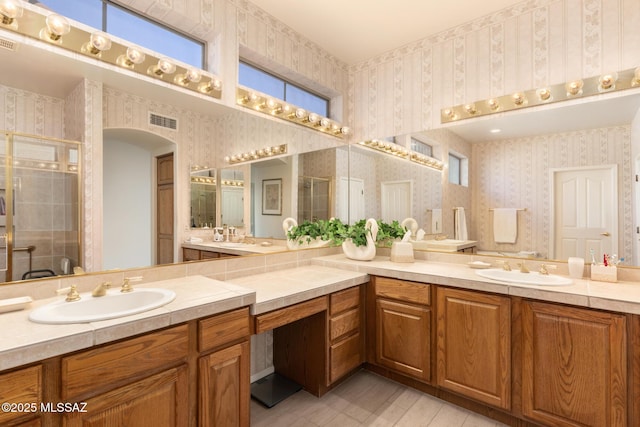 bathroom featuring vanity, a shower stall, visible vents, and wallpapered walls