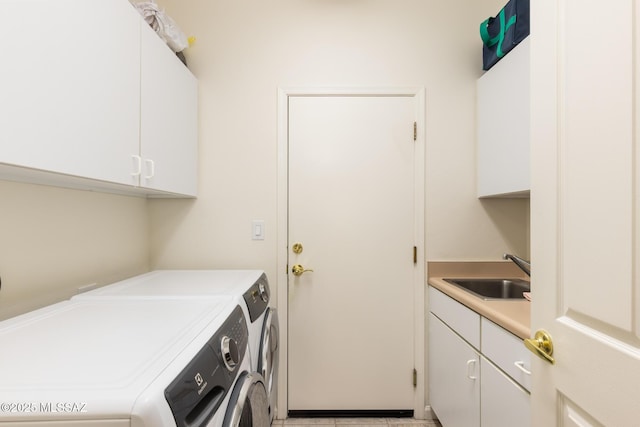 washroom featuring washer and dryer, sink, and cabinets