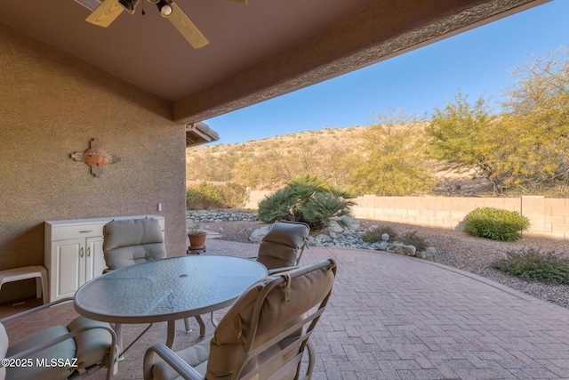 62218 E Sand Crest Dr, Saddlebrooke, AZ 85739 - fenced backyard with a patio area, a ceiling fan, outdoor dining area, and a mountain view