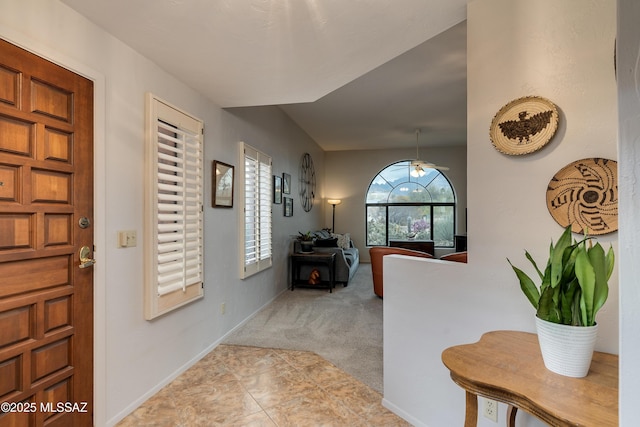 foyer with a wealth of natural light and light colored carpet