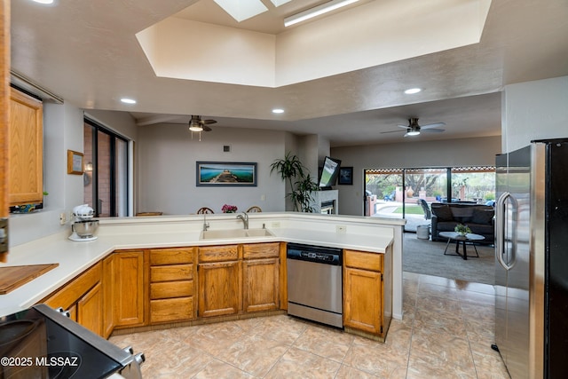 kitchen with sink, kitchen peninsula, ceiling fan, and appliances with stainless steel finishes