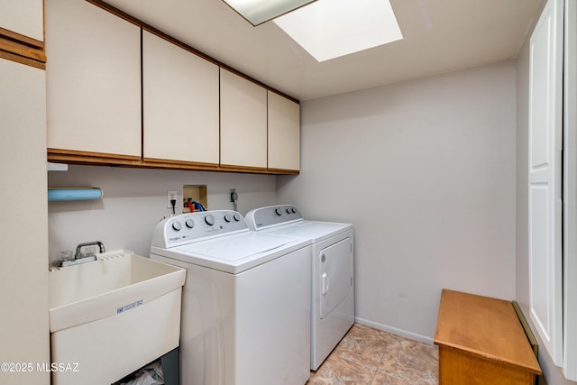 clothes washing area with cabinets, sink, washer and clothes dryer, and a skylight