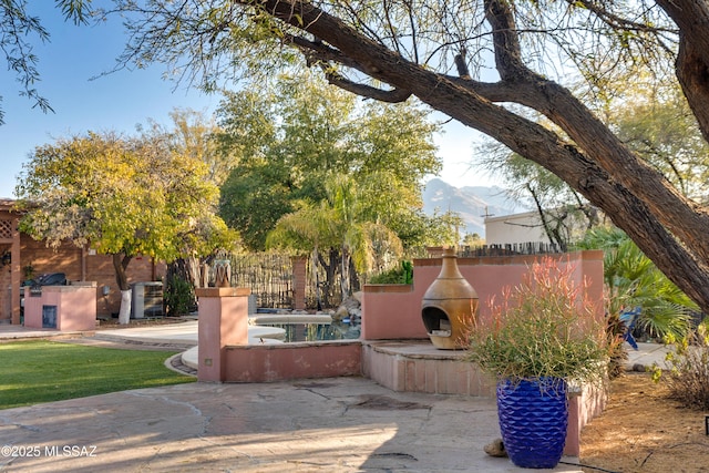 view of patio featuring exterior fireplace and a mountain view