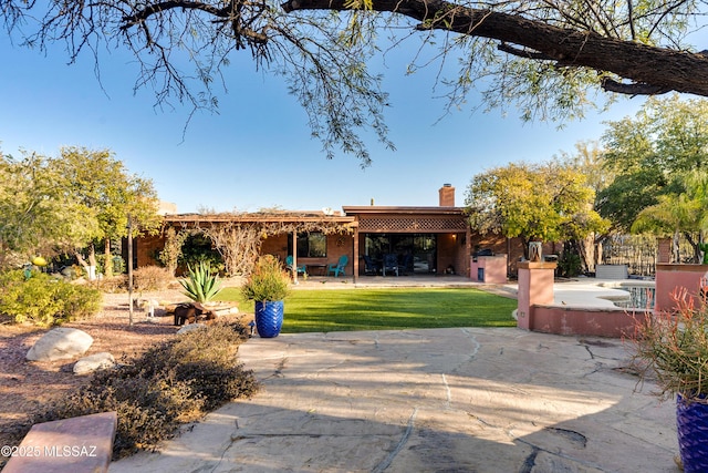 back of house featuring a yard and a patio area